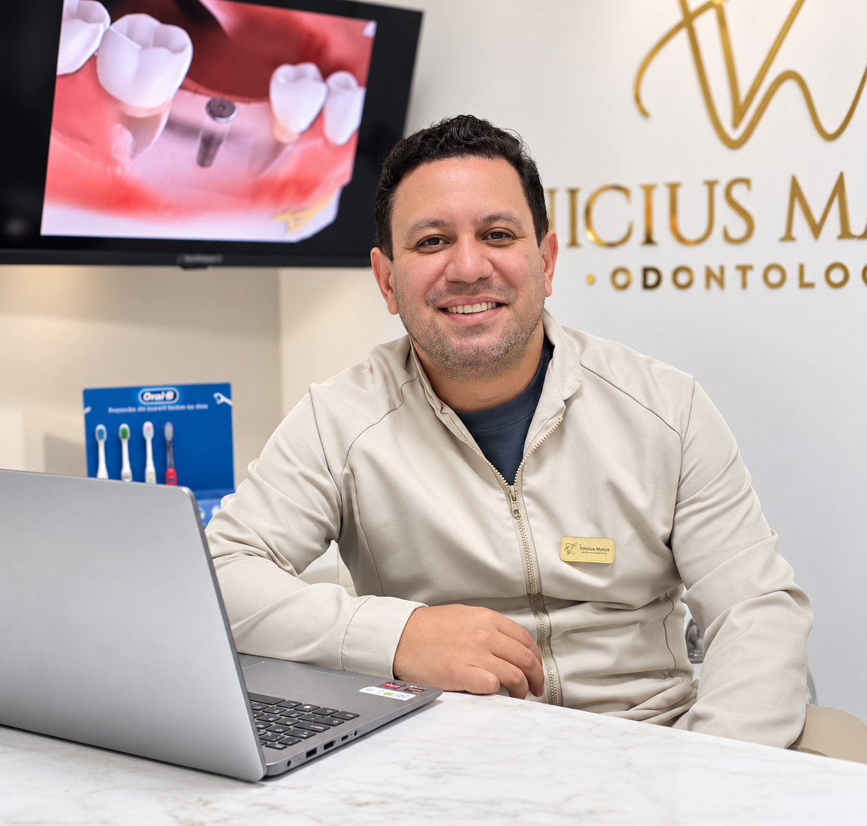 Dr. Vinícius Martins sorrindo à mesa em seu consultório